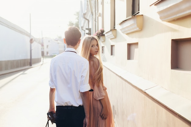 Foto giovani coppie dei bei pantaloni a vita bassa nei ritratti della via di estate di amore nella città