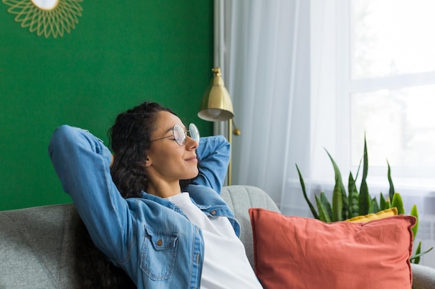 Beautiful hispanic woman at home close up with closed eyes relaxing sitting on couch woman with