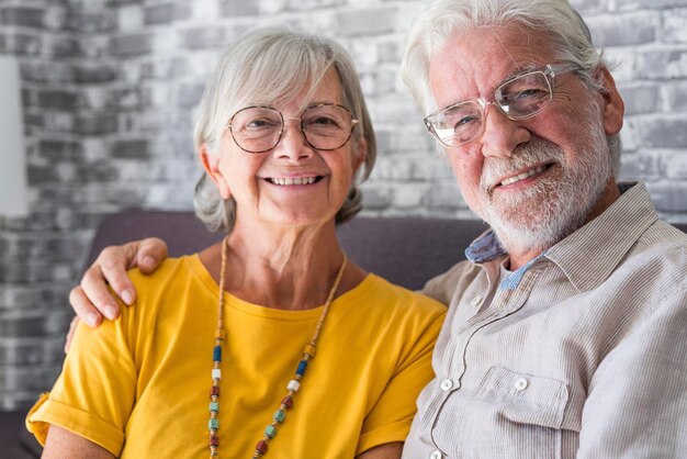 Photo beautiful hoary goodlooking mature spouses relaxing together on comfy couch at modern home smiling staring at camera feel carefree good harmonic relationships happy marriage endless love concept