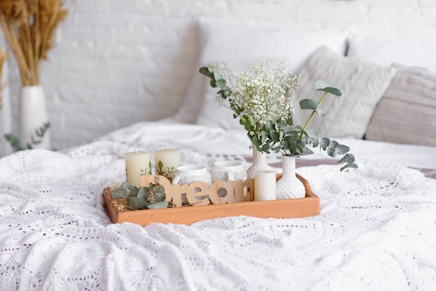 Photo beautiful home interior with white and beige tones, with dream catchers, dry flowers and a bed