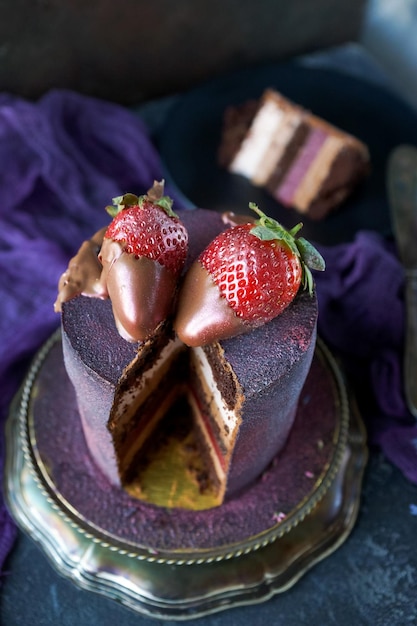 Beautiful homemade artwork purple cake decorated with chocolate and strawberries