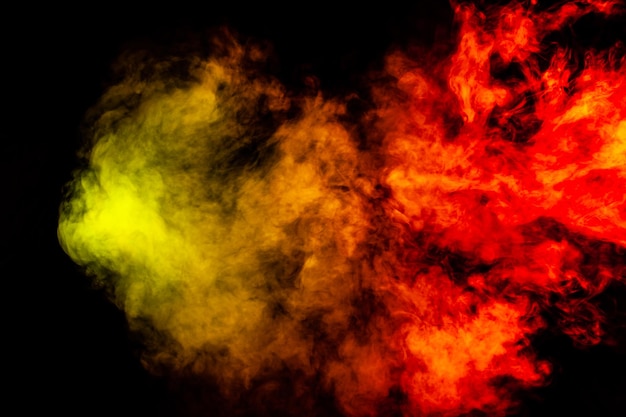 Beautiful horizontal column of smoke in the neon bright light of red green yellow and orange on a black background exhaled out of the vape Nice pattern for printing and backdrop of colored waves