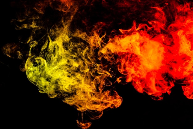 Beautiful horizontal column of smoke in the neon bright light of red green yellow and orange on a black background exhaled out of the vape Nice pattern for printing and backdrop of colored waves