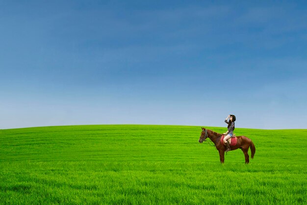 Photo beautiful horse rider at green field