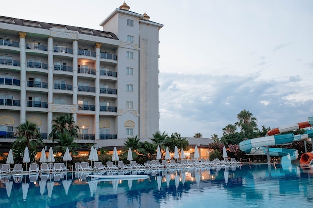 beautiful hotel with swimming pool and aqua slides in the evening the concept of tourism