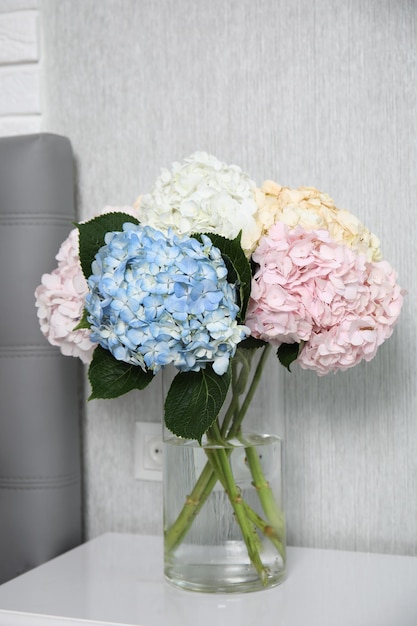 白いベッドサイドテーブルの花瓶の中の美しいホルテンジアの花