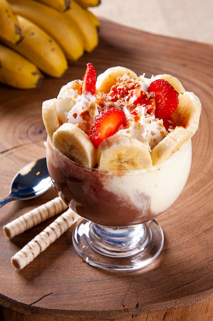 Photo beautiful ice cream bowl decorated with strawberries, bananas, chestnuts and whipped cream