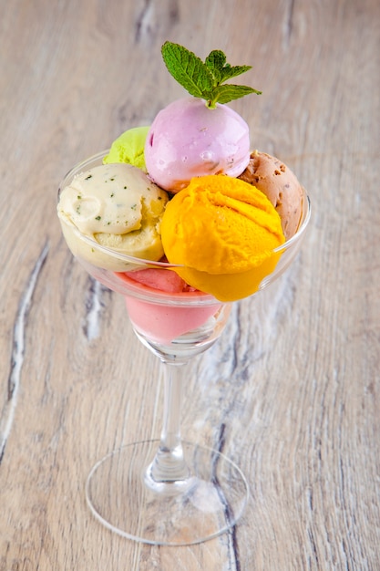 beautiful ice cream in a transparent bowl on a wooden background
