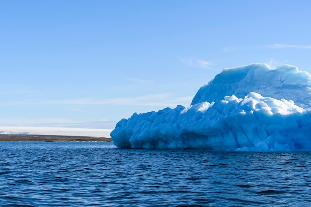 Foto bellissimo iceberg nel mare artico al giorno pieno di sole. grande pezzo di ghiaccio in mare da vicino.