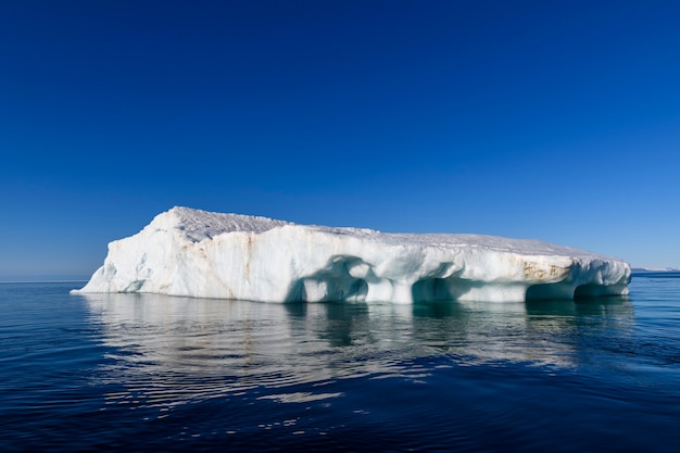 Beautiful iceberg in Arctic sea at sunny day. Big piece of ice in sea close up.