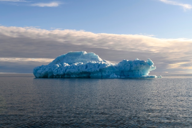 Beautiful iceberg in Arctic sea at sunny day. Big piece of ice in sea close up.