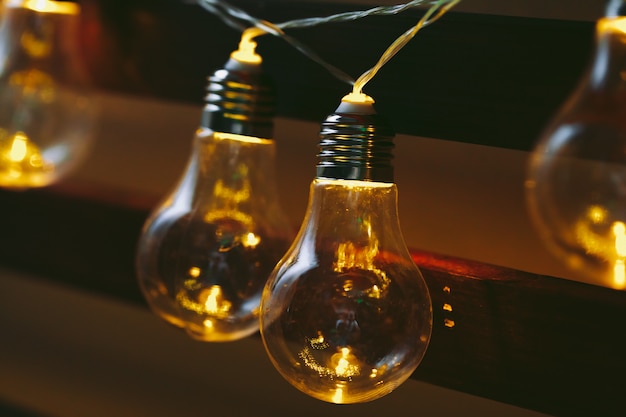 Beautiful illuminated festive light bulbs garland close up