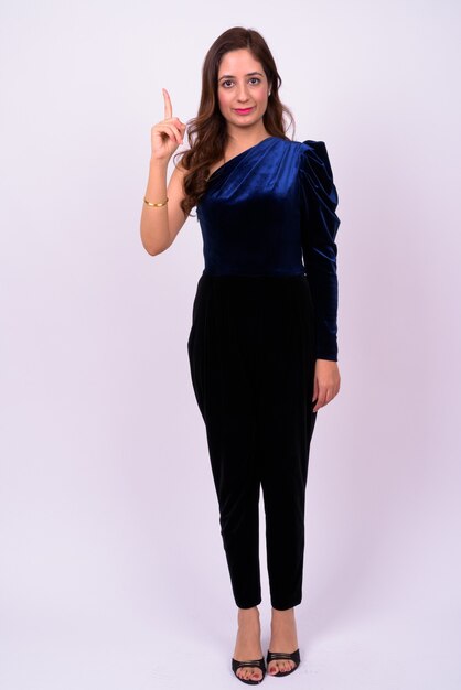  beautiful Indian businesswoman with wavy hair against white wall