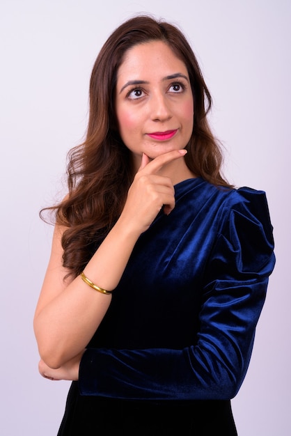  beautiful Indian businesswoman with wavy hair against white wall