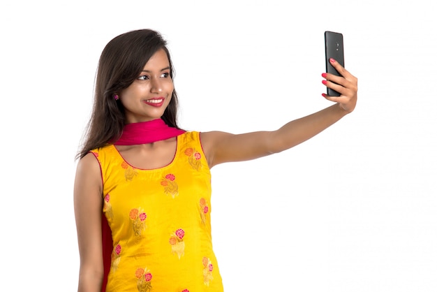 Bella ragazza indiana in un costume tradizionale con un telefono
