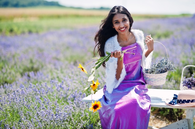 美しいインドの女の子は紫色のラベンダー畑でサリーインドの伝統的なドレスを着ています。