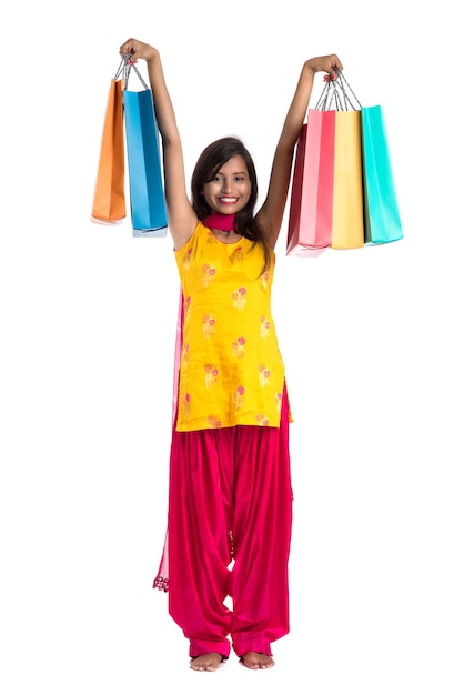 Красивая индийская женщина в традиционном сари, держащая хозяйственные сумки