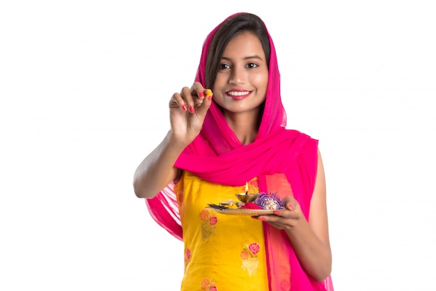 Beautiful Indian young girl holding pooja thali or performing worship