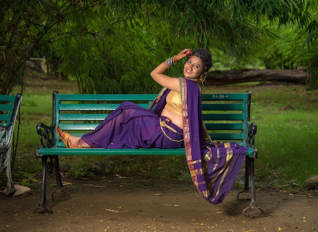 Beautiful Indian young girl in Traditional Saree posing outdoors