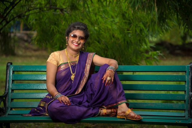 Beautiful Indian young girl in Traditional Saree posing outdoors