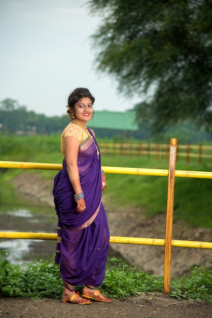 Beautiful Indian young girl in Traditional Saree posing outdoors