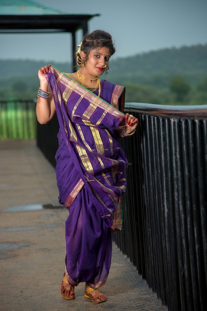 Beautiful Indian young girl in Traditional Saree posing outdoors