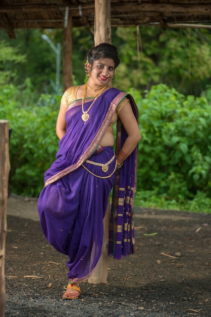 Beautiful Indian young girl in Traditional Saree posing outdoors