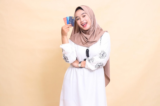 a beautiful indonesia Muslim woman wearing a hijab with a cheerful smile and her arms holding a debi