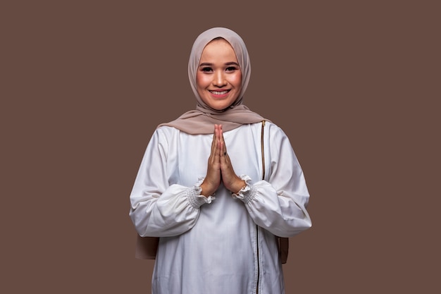 Beautiful Indonesian muslim woman greetings gesture typical of Ramadan and celebrating Eid Al-Fitr