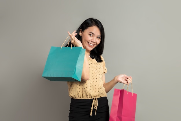 Beautiful Indonesian woman smiling while holding shopping bags