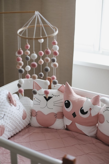 beautiful interior of baby room with a crib with pillows and pink blanket