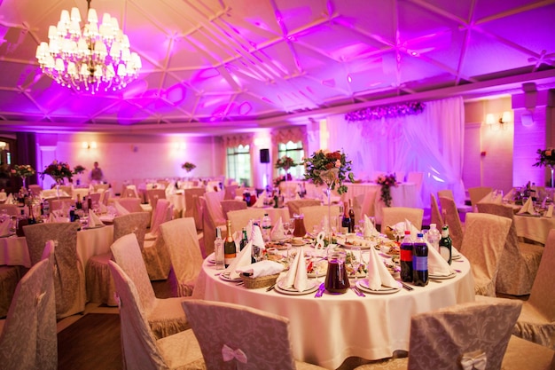 Beautiful interior of a large festive hall and decorated tables with food