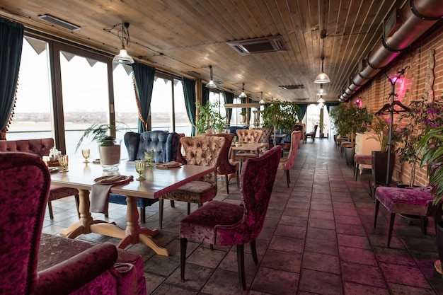 Beautiful interior of the restaurant in semiantique dark brown shades Served tables