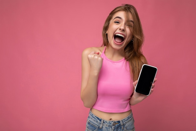 Beautiful joyful young blonde woman wearing pink top