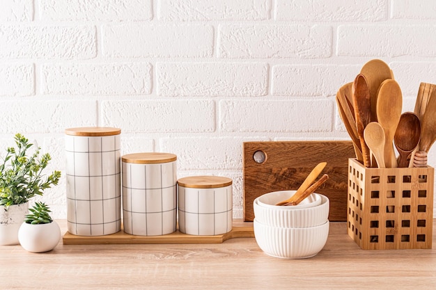 Beautiful kitchen background with set of cutting boards wooden spoons bowls ceramic stylish storage jars Front view Ecofriendly kitchen