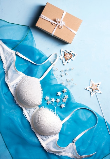 Bellissimo reggiseno in pizzo, vicino a stelle di perle, rami di abete e confezione regalo