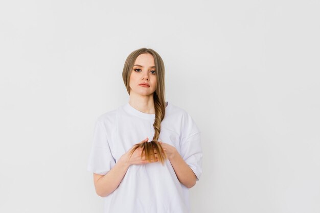 Beautiful lady doing her make up and hair in bedroom. Attractive young female with pretty long hair