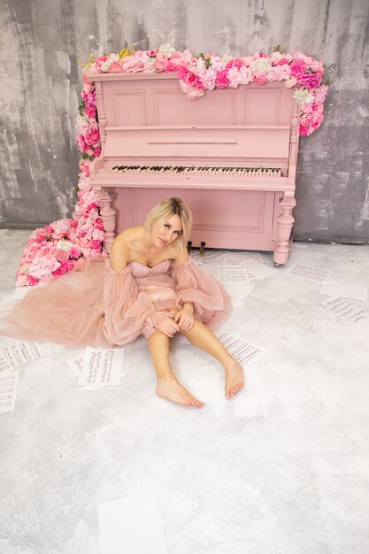 Beautiful lady in pink dress and pink piano