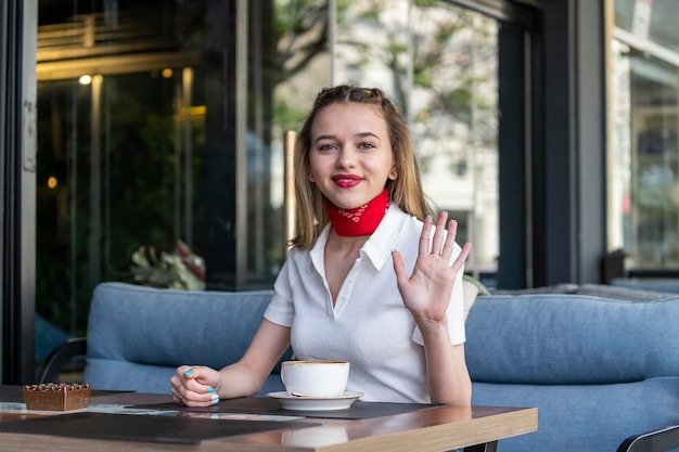 Beautiful lady sitting at the restaurant and shaking her hand to the camera