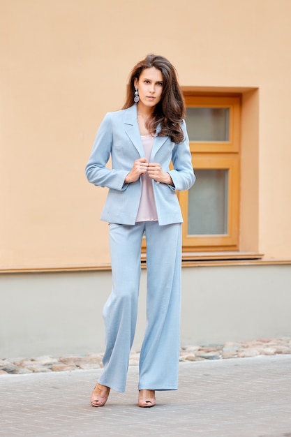 Bella signora in tailleur pantalone azzurro sulla strada