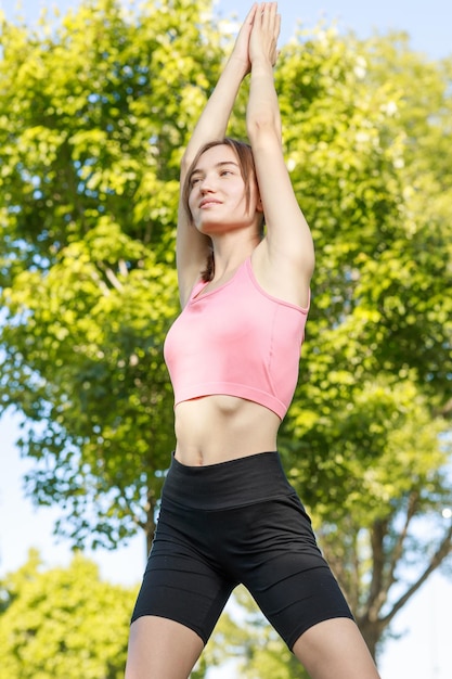 Beautiful lady standing at the park and looking to the camera