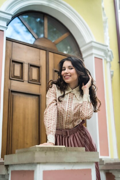 Beautiful lady wear elegant cloth standing near a city building