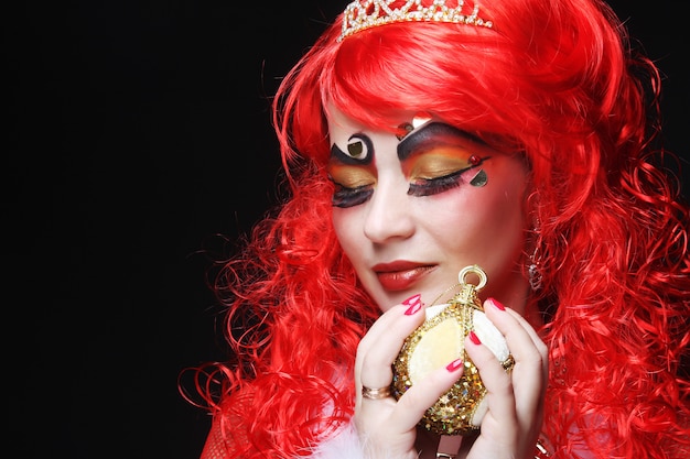 Beautiful lady with artistic make-up holding Christmas decoration