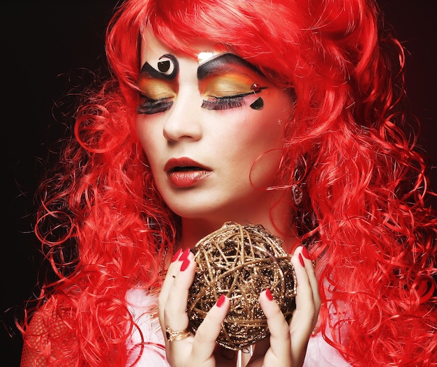 Beautiful lady with artistic makeup holding Christmas decoratio