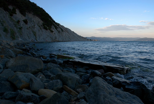 夕方の海岸の美しい風景黒海ピンクの夕日岩の多い海岸無限の海
