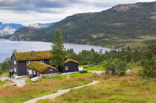 Beautiful landscape of norway homes with green roofs and\
mountainous terrain and reservoirs