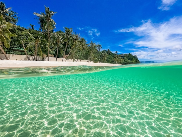 Красивый пейзаж на тропическом пляже острова Боракай, Филиппины. Кокосовые пальмы, море, парусник и белый песок. Вид на природу. Концепция летних каникул.