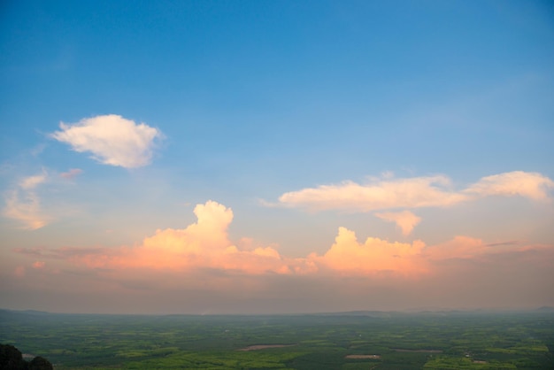 Beautiful landscape with blue sky and dramatic sunset above green countryside