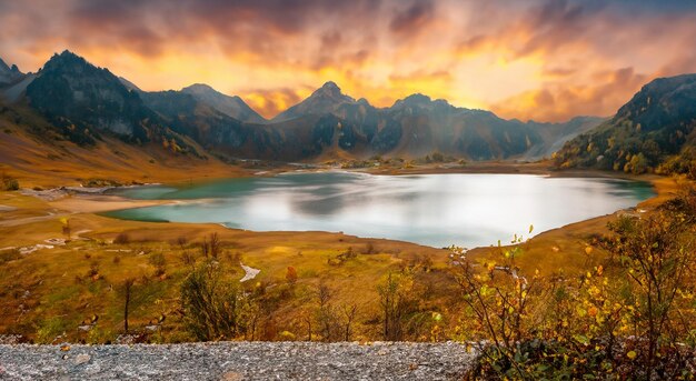 Beautiful landscape with a lake in autumn and the sun in the background