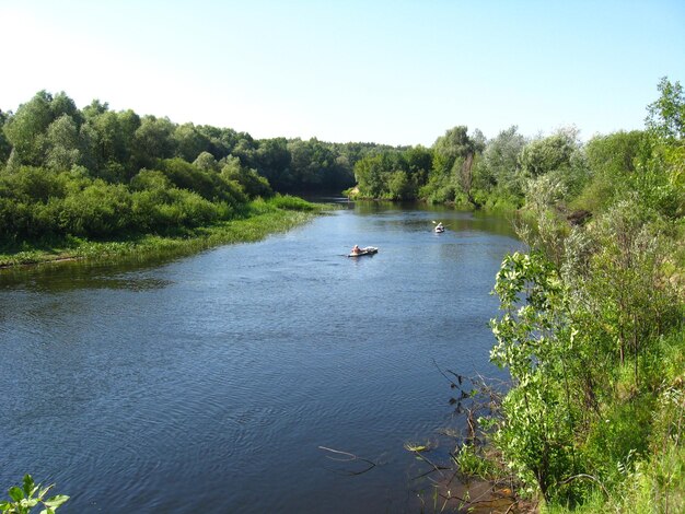 Beautiful landscape with river and canoe with people on it